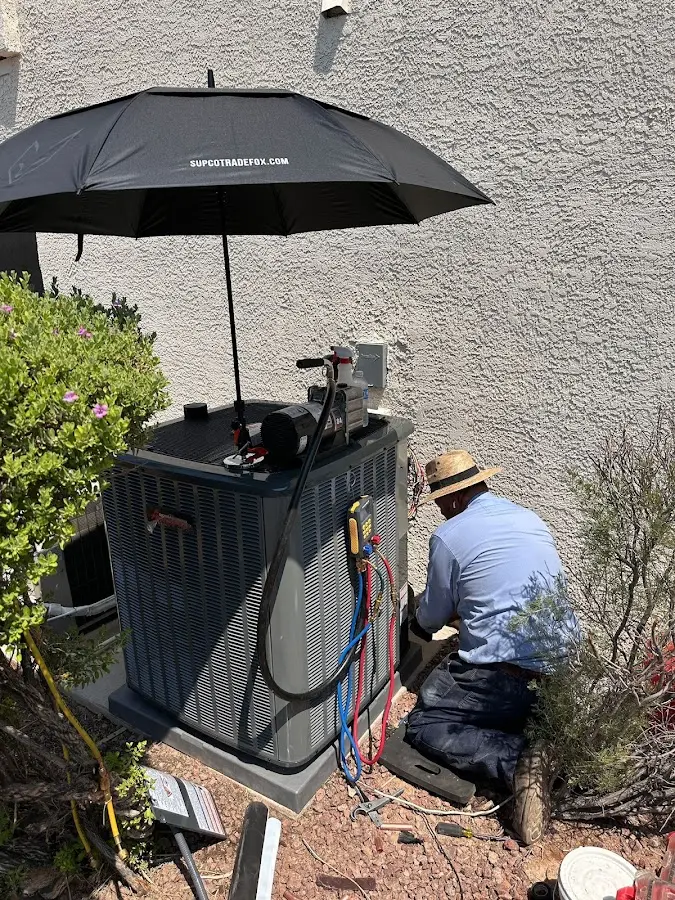 HVAC technician performing outdoor AC maintenance in Coral Hills