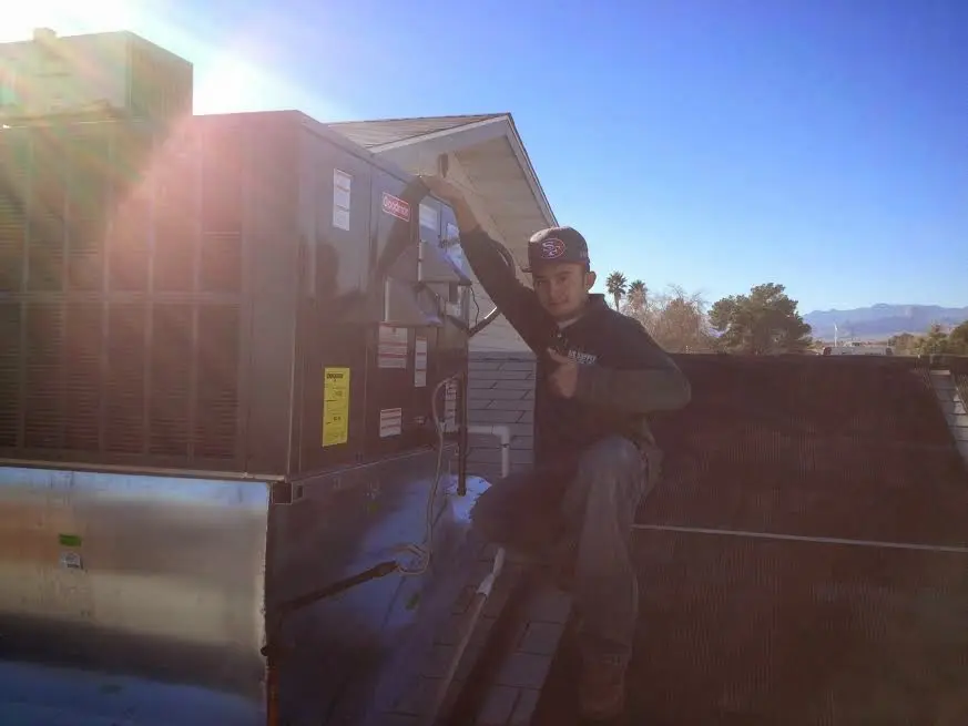 HVAC technician performing AC Tune-Up on a rooftop unit in Coral Hills